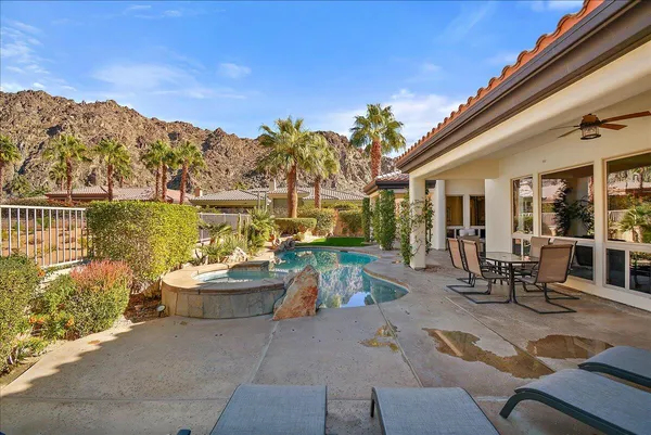 a view of a patio with couches table and chairs and potted plants