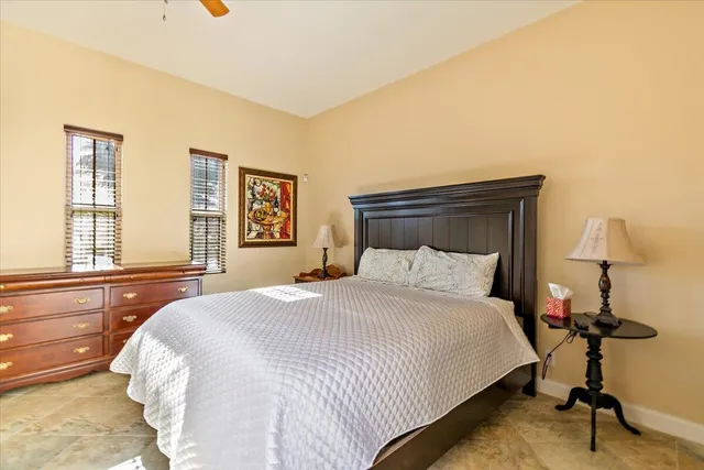 a bedroom with a bed and a dresser next to a window
