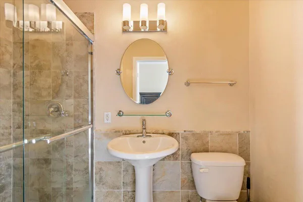 a bathroom with a toilet sink and mirror