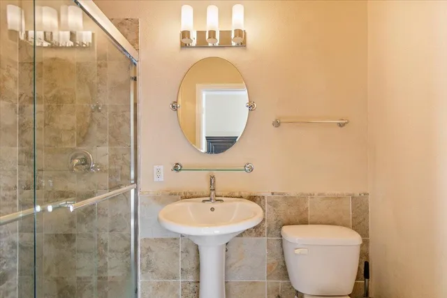 a bathroom with a toilet sink and mirror