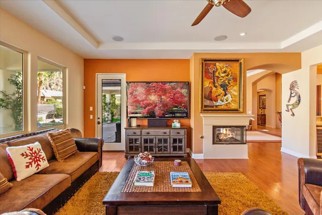 a living room with furniture a rug and a floor to ceiling window