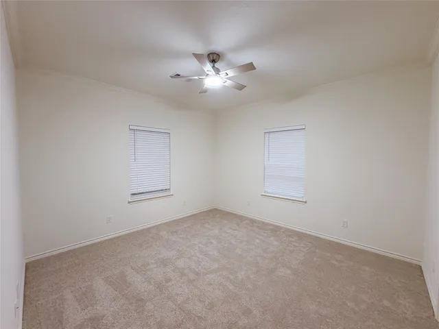 a view of an empty room with a ceiling fan and window