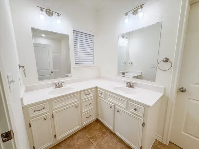 a spacious bathroom with a sink double vanity and a mirror