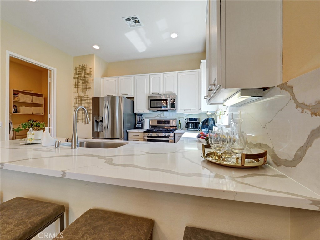 887 Westchester Road Beaumont, CA 92223 - Photo 13 of 41 a kitchen with a sink a stove and cabinets