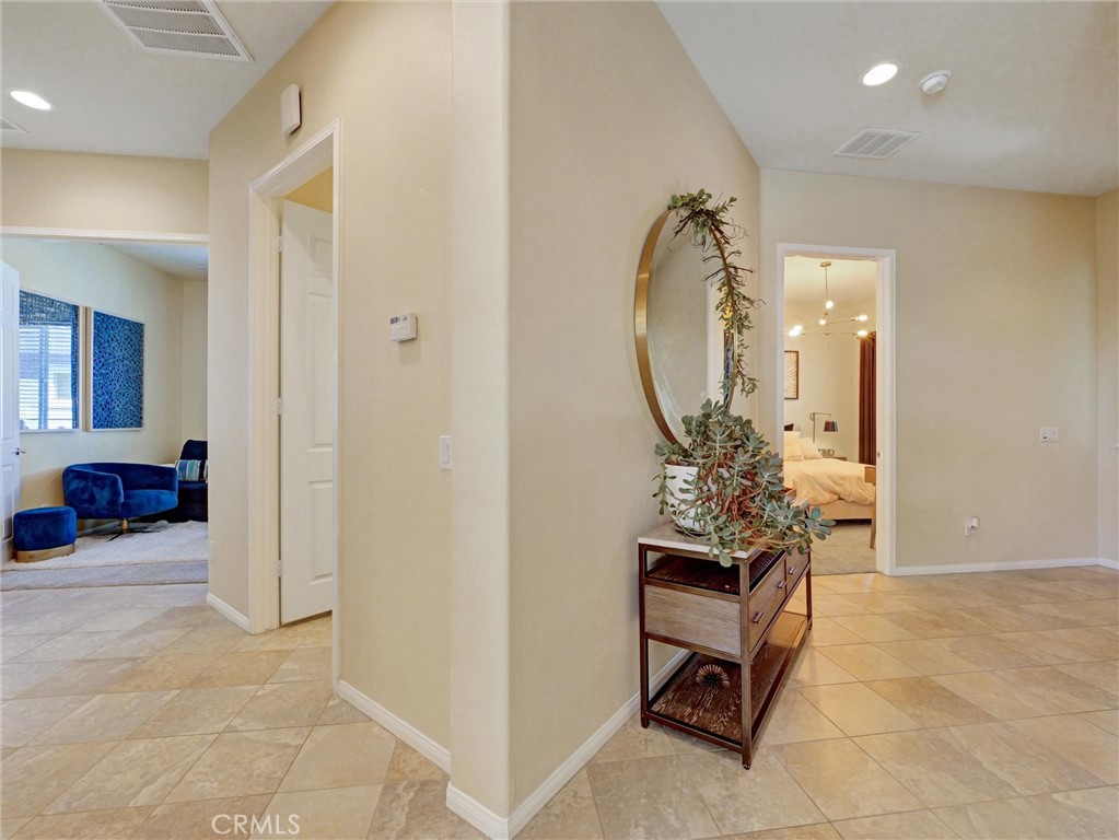 887 Westchester Road Beaumont, CA 92223 - Photo 5 of 41 a view of a hallway to a livingroom and a livingroom with furniture