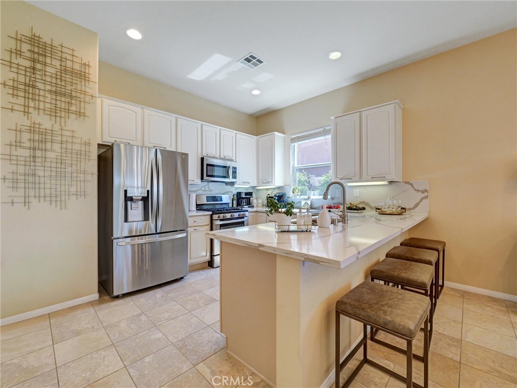887 Westchester Road Beaumont, CA 92223 - Photo 6 of 41 a kitchen with kitchen island a sink appliances and cabinets