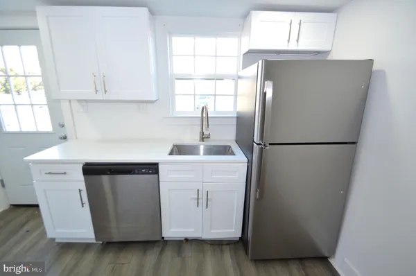 a kitchen with a refrigerator sink and cabinets
