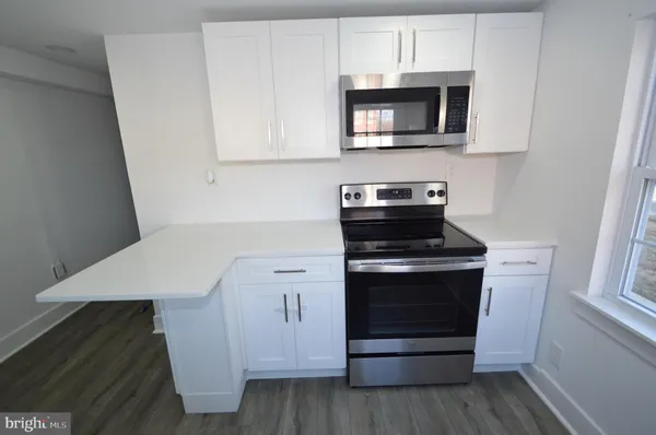 a kitchen with stainless steel appliances a stove microwave and sink