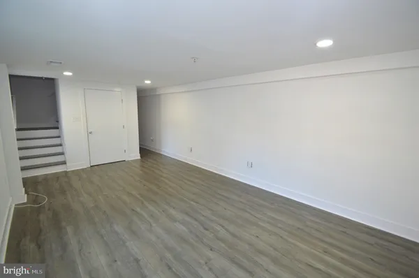an empty room with wooden floor and white walls