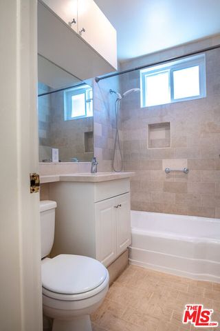 a bathroom with a granite countertop toilet sink and mirror