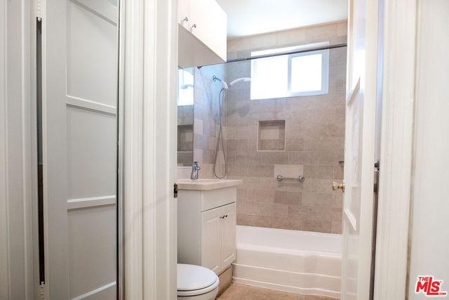 a bathroom with a granite countertop bathtub shower and toilet