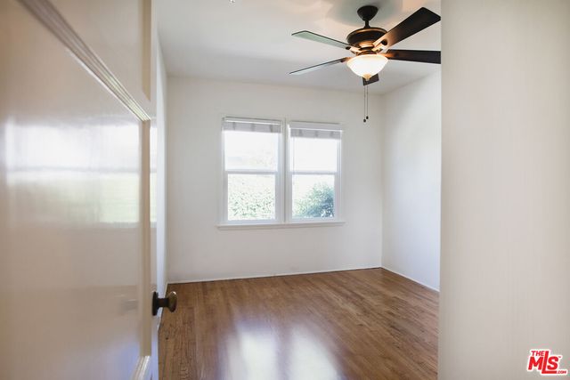 an empty room with a window and a fan