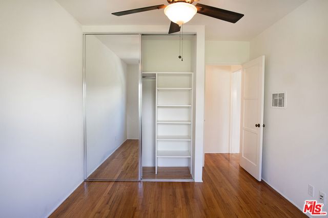 a view of walk in closet with wooden floor