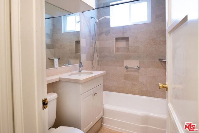 a bathroom with a bathtub shower sink vanity and a toilet