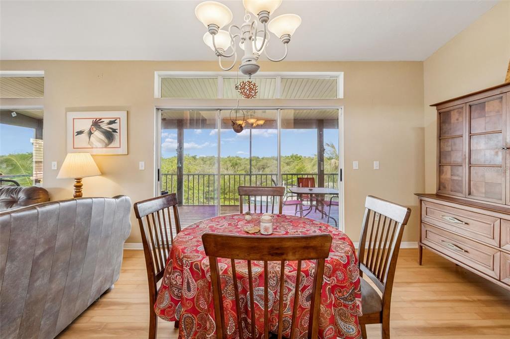 119 Burns Road Terra Ceia, FL 34250 - Photo 26 of 100 a view of a dining room with furniture a chandelier and wooden floor