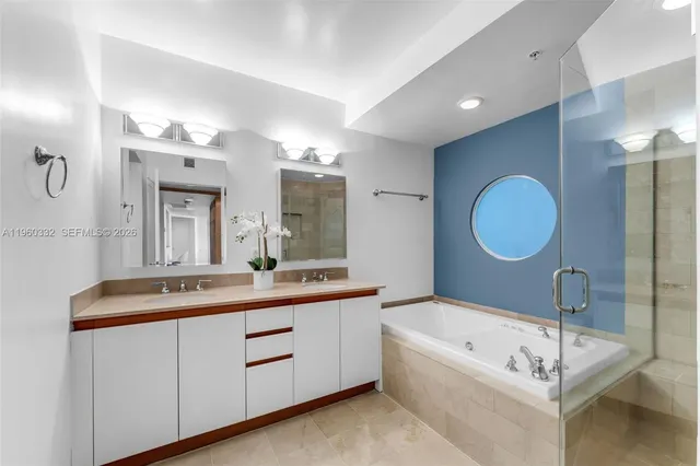 a bathroom with a double vanity sink mirror and bathtub