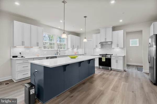a large kitchen with stainless steel appliances kitchen island granite countertop a sink and cabinets