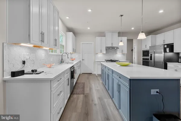 a kitchen with kitchen island a sink a counter top space stainless steel appliances and cabinets