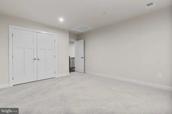 an empty room with wooden floor and staircase