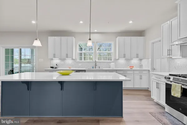 a kitchen with stainless steel appliances granite countertop a sink a stove and a refrigerator
