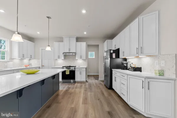 a large kitchen with stainless steel appliances lots of counter space and a sink
