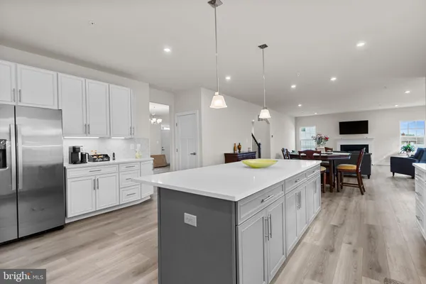 a large kitchen with kitchen island a sink a stove a dining table and chairs