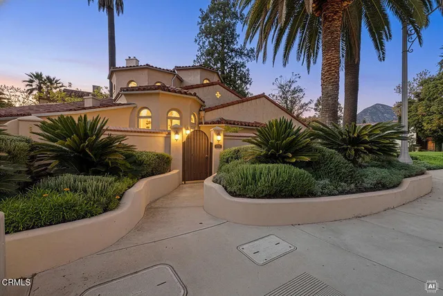 a view of a house with a yard and potted plants