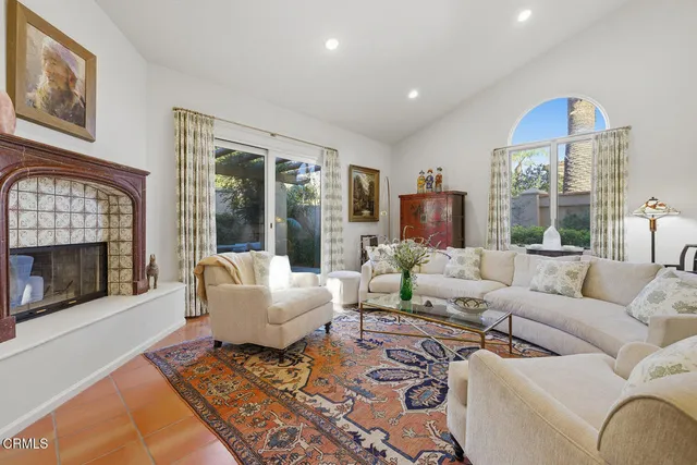 a living room with furniture fireplace and a large window