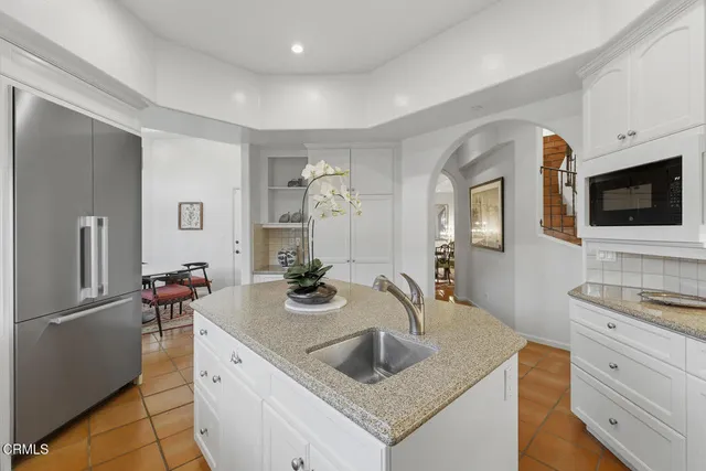 a kitchen with stainless steel appliances granite countertop a sink and a refrigerator