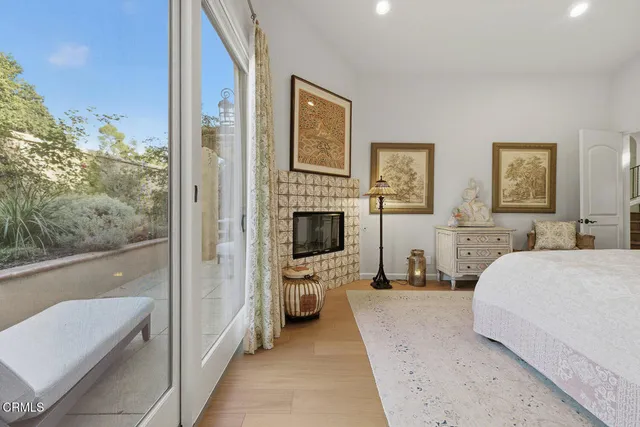 a bedroom with a bed couch painting on wall and a large window