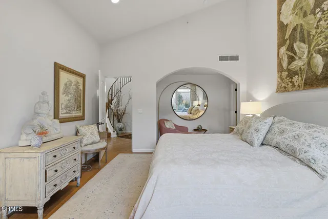 a bedroom with a bed and a mirror on dresser