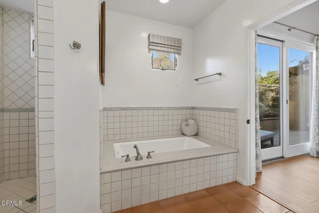 a bathroom with a tub a sink and mirror