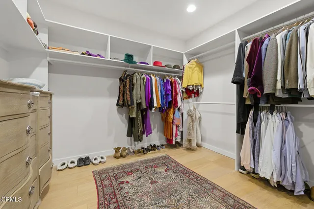 a view of walk in closet with clothes
