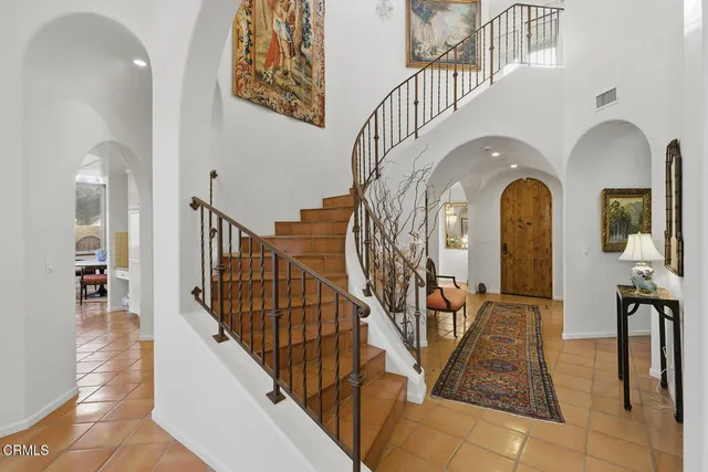 a view of staircase with lots of frames on wall and a view of entryway