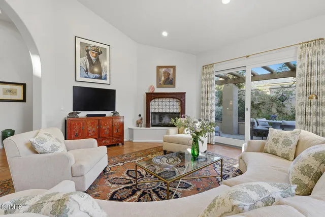 a living room with furniture a flat screen tv and a large window