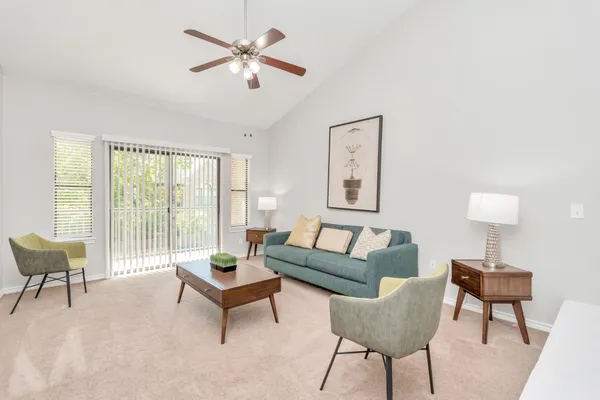 a living room with furniture a lamp a rug and a large window
