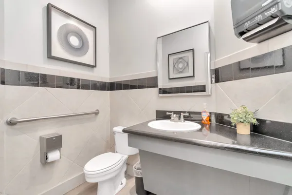 a bathroom with a toilet sink and mirror