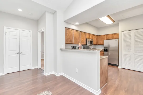 a kitchen with stainless steel appliances granite countertop a refrigerator and a stove top oven