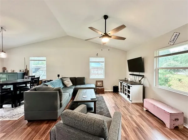 a living room with furniture ceiling fan and a flat screen tv