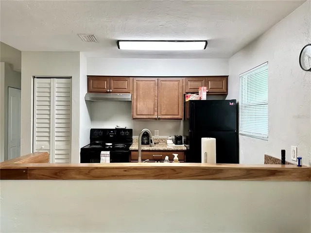 a kitchen with stainless steel appliances granite countertop a refrigerator and a stove