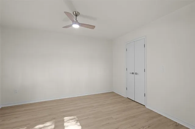 a view of a room with wooden floor and a ceiling fan