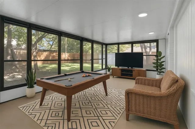 a living room with furniture a rug and a floor to ceiling window