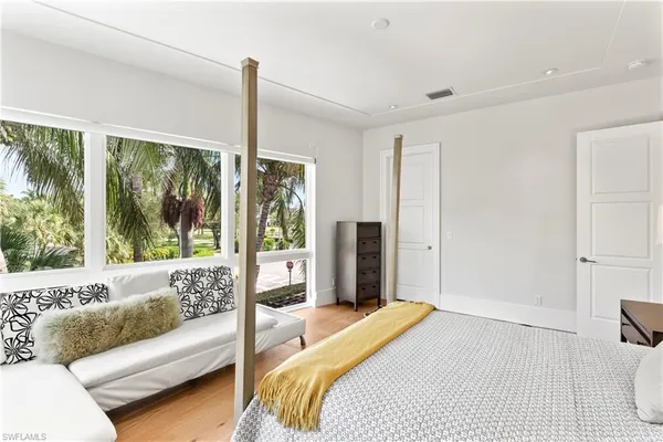 a bedroom with a bed couch and a large window