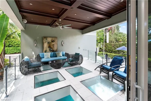 a living room with patio furniture and a potted plant