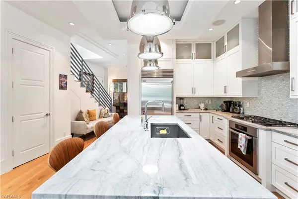 a kitchen with stainless steel appliances granite countertop a stove and a white cabinets