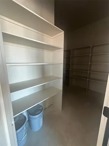 a view of walk in closet with empty racks
