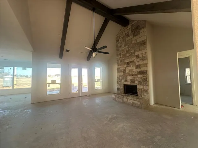a view of an empty room with a fireplace and a window