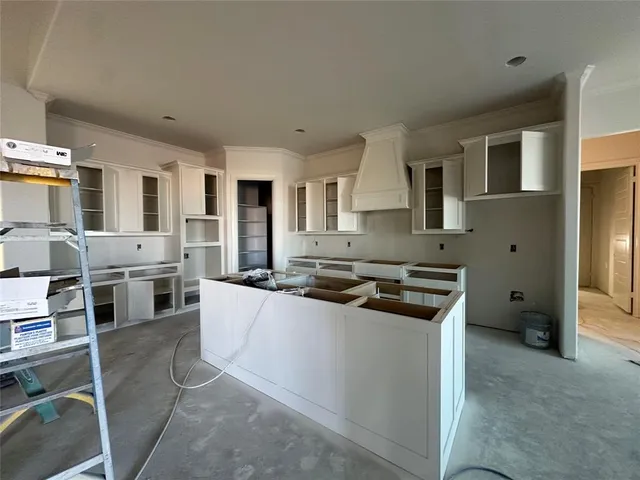 a kitchen with stainless steel appliances granite countertop a stove top oven a sink a counter space and cabinets