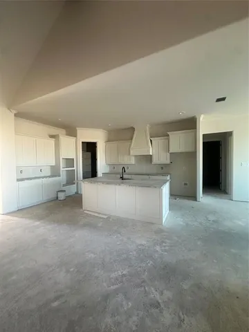 a view of a kitchen with a sink and dishwasher cabinet a fireplace