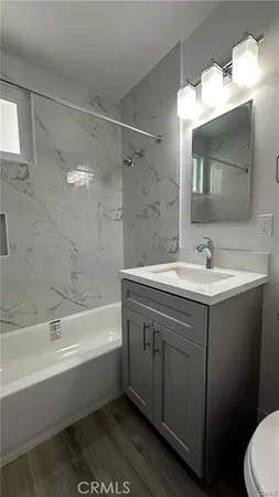a bathroom with a sink double vanity mirror and a bathtub